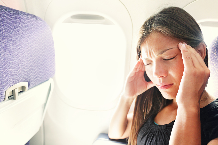Fear of flying woman in plane airsick with stress headache and m